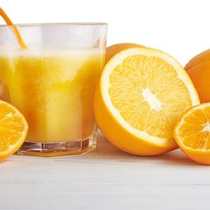Close up image of fresh orange juice and orange fruits standing on a wooden table isolated at white background
