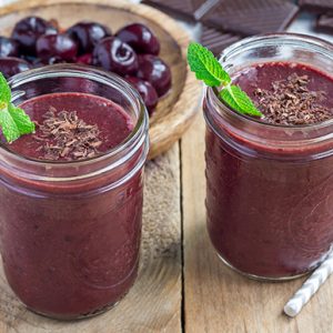 Black forest smoothie with cherry, almond milk and cacao powder in glass jar, horizontal