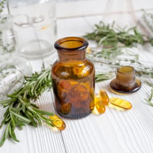 concept - natural medicine herbs in bottles on wooden background.
